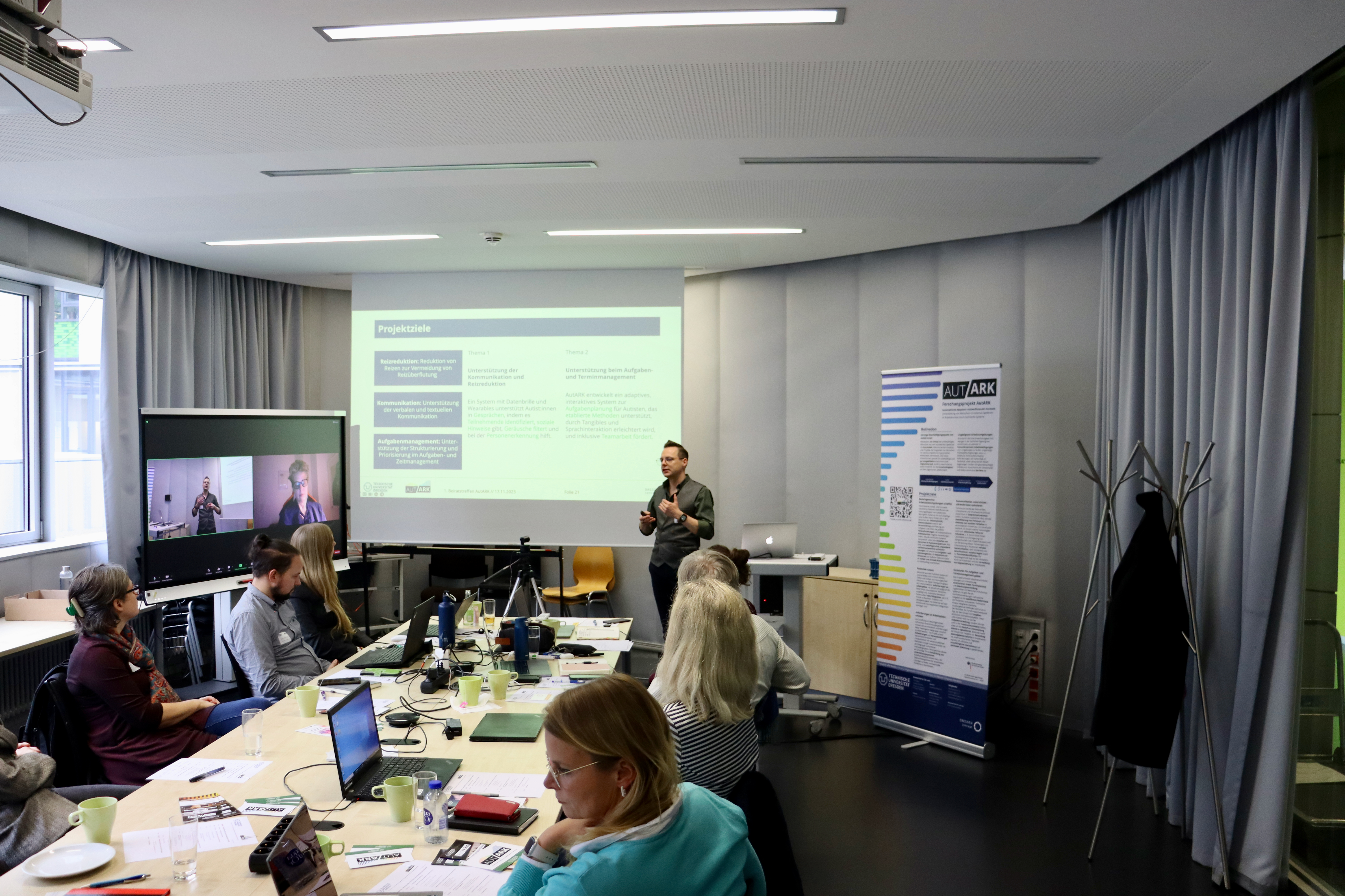 Foto einer Präsentation zum Projektplan, den Projektzielen und der Projektidee, die von David Gollasch gehalten wird (vorne rechts)